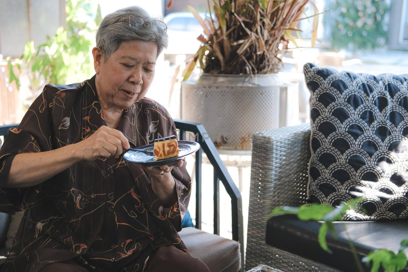 old asian elderly senior elder woman eating cheesecake at home