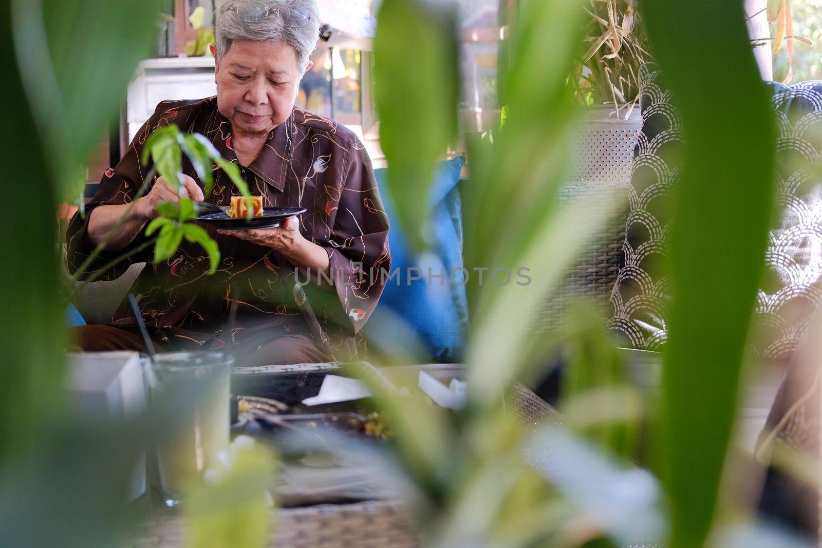 old asian elderly senior elder woman eating cheesecake at home