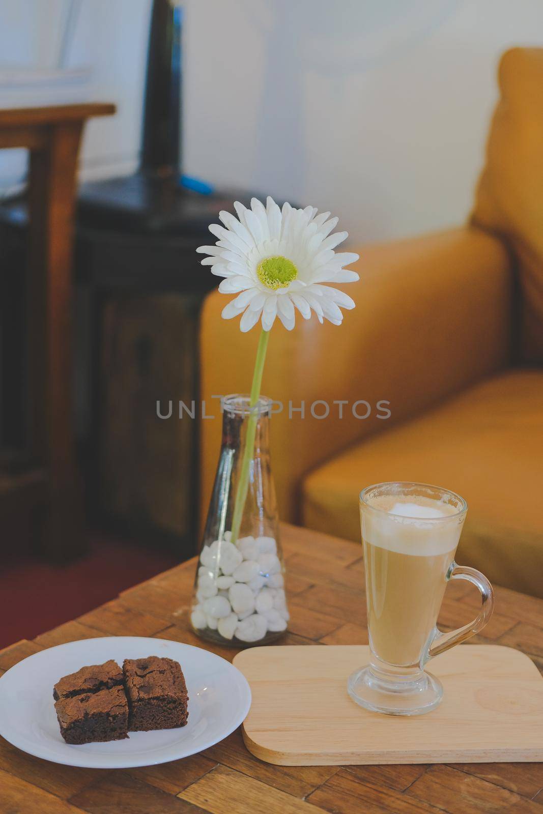 artificial white gerbera flower with brownie and hot latte cappuccino mocha coffee.