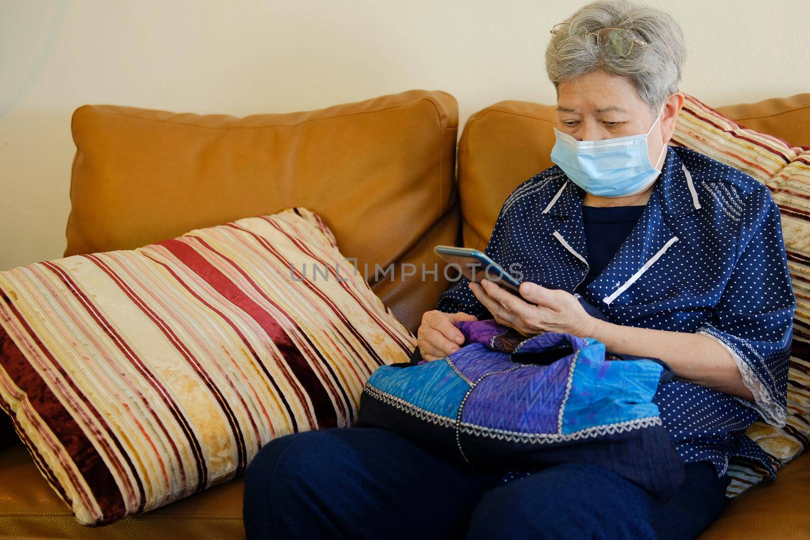 asian elder senior woman elderly wearing facial mask using mobile smart phone cellphone. mature retirement lifestyle