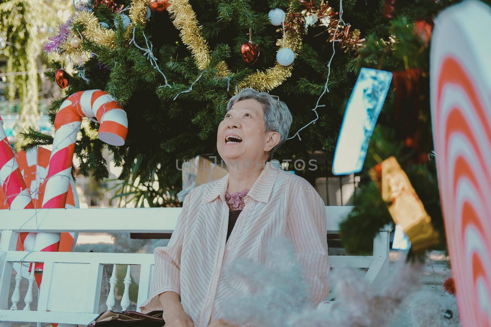 asian old elder woman elderly senior sitting near christmas tree