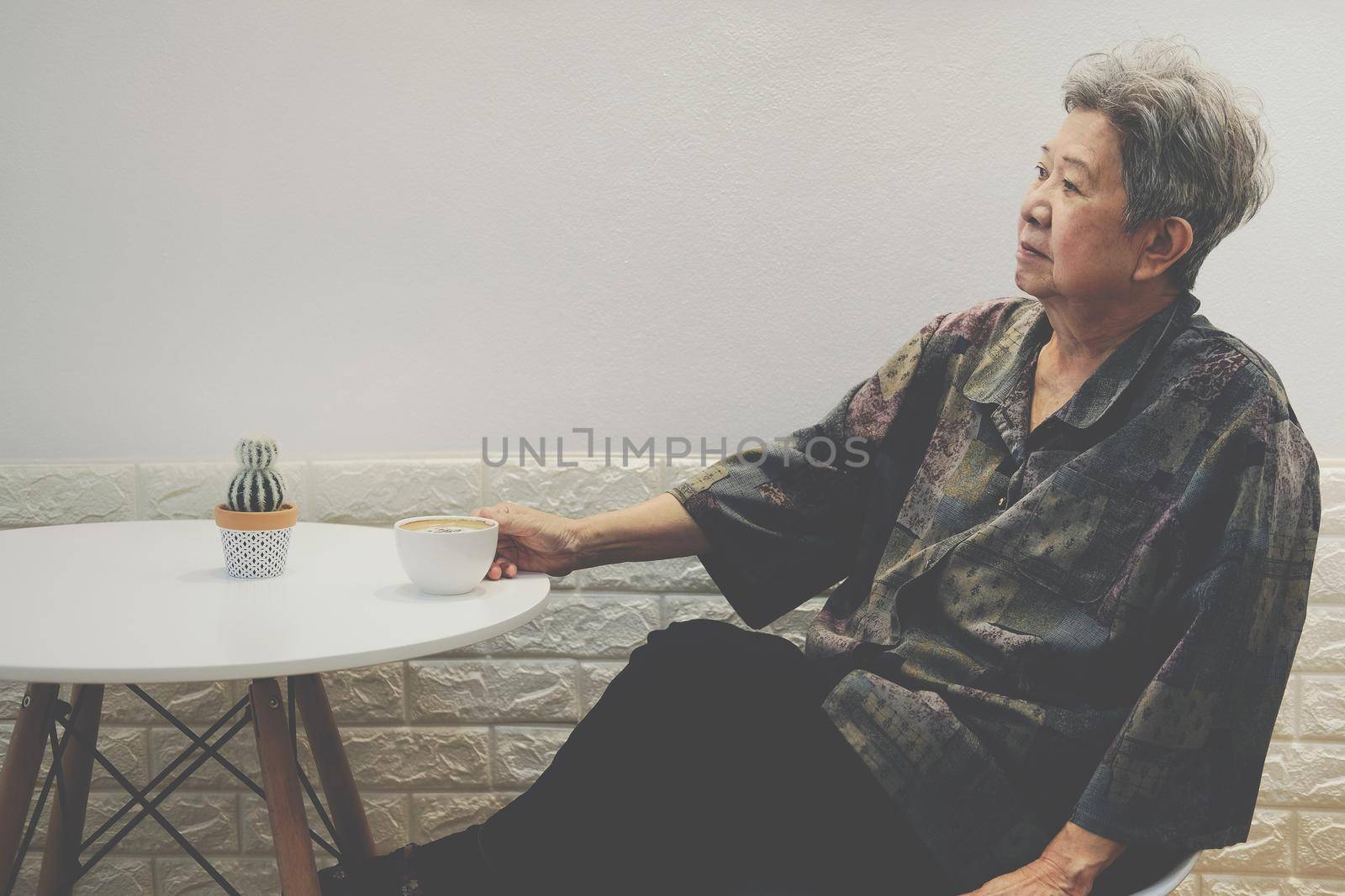old elderly senior elder woman drinking hot mocha coffee tea at home. mature retirement lifestyle