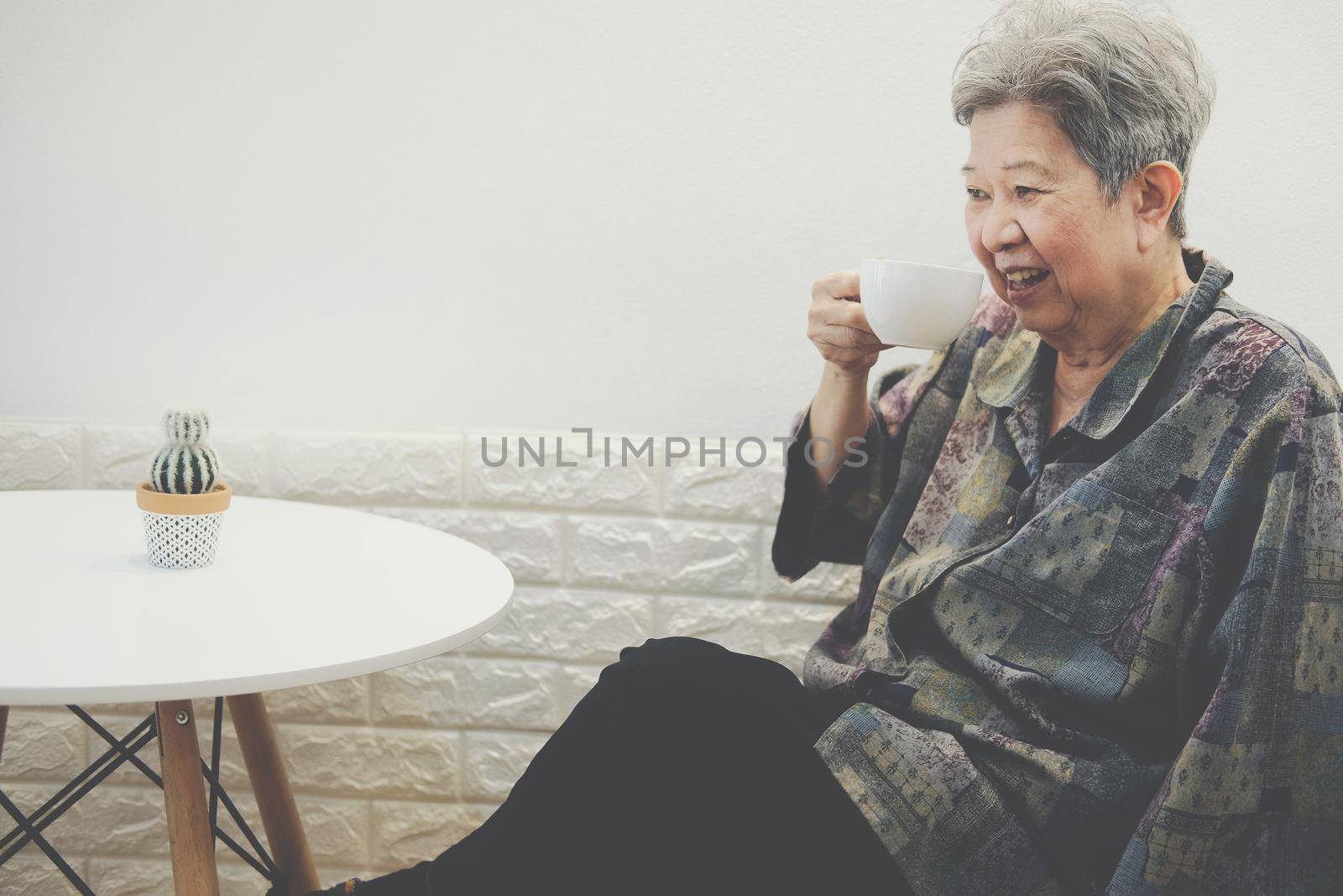 old elderly senior elder woman drinking hot mocha coffee tea at home. mature retirement lifestyle