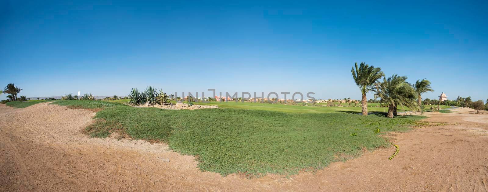 Panoramic view across golf course through beautiful landscaped gardens in tropical hotel resort