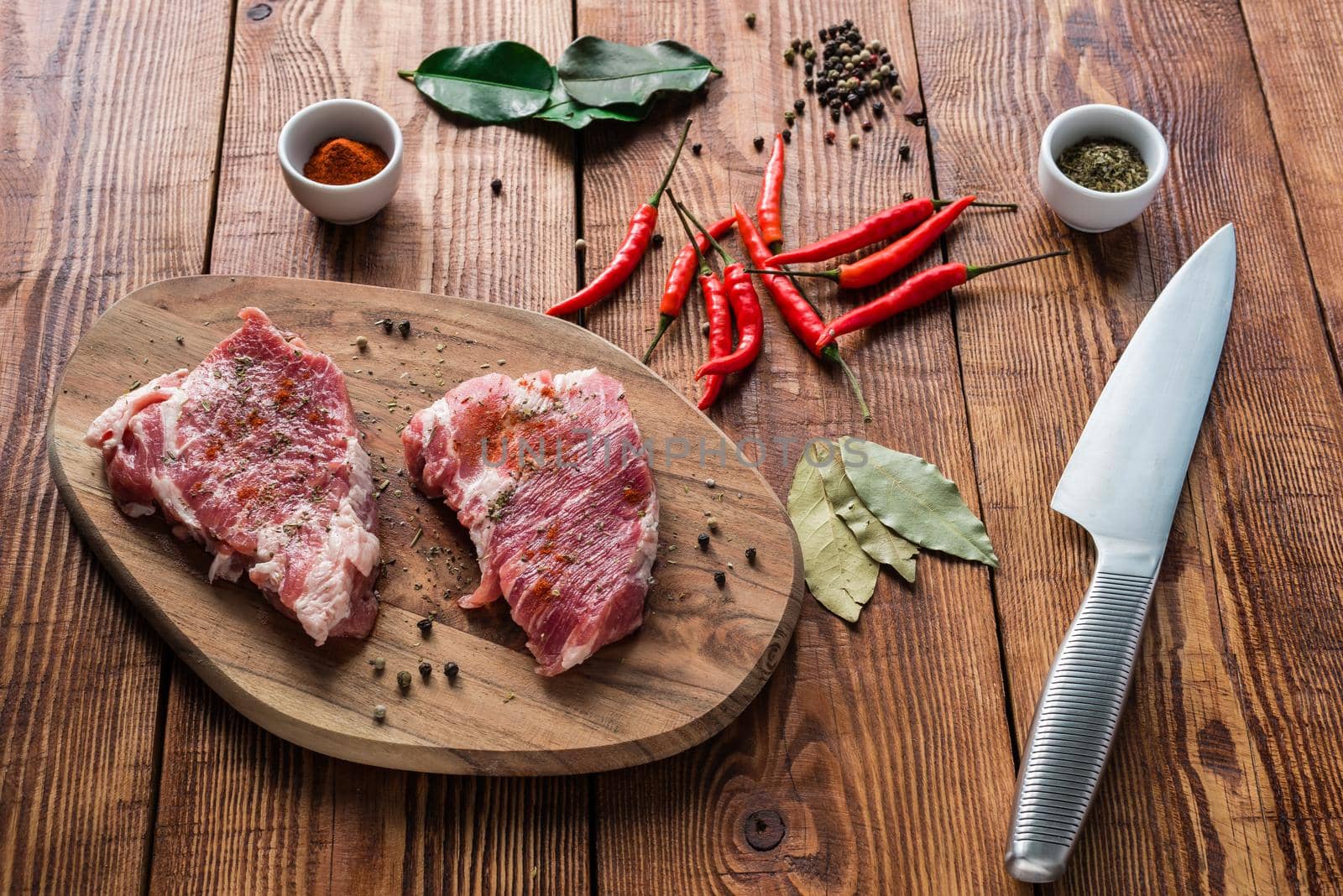 Meat with some condiment on kitchen table. Ready for cooking.