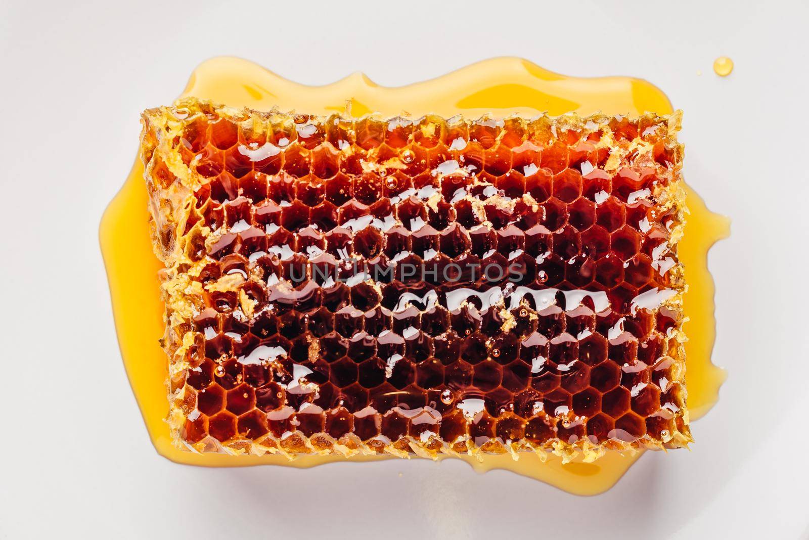 Top view of delicious yummy honeycomb on bright plate over light wooden background