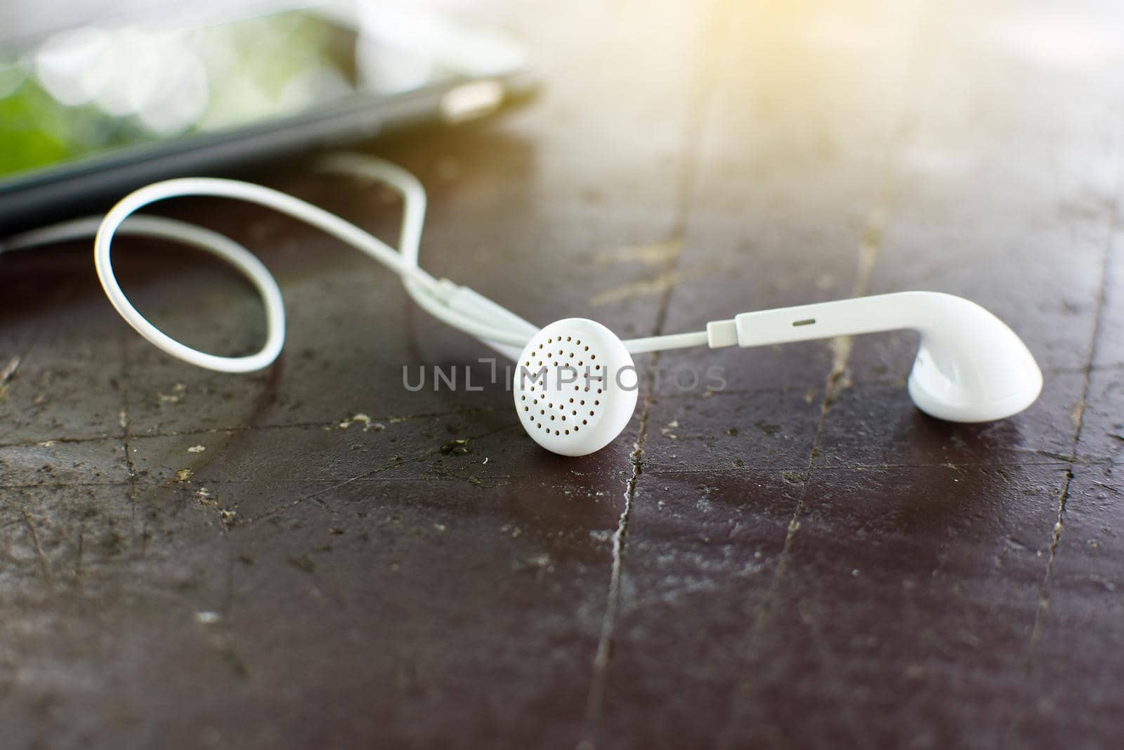 White earphone on desk with soft light