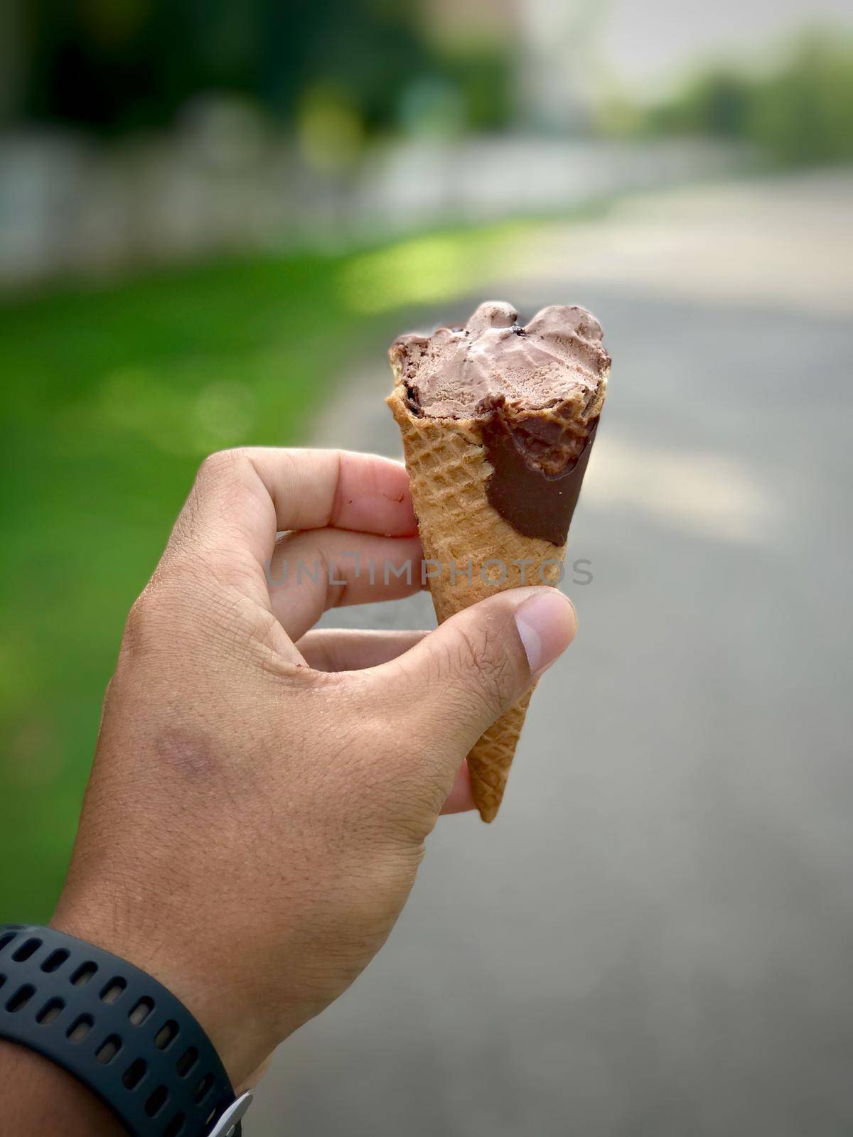Hand holding ice cream with defocus nature background. Summer season.