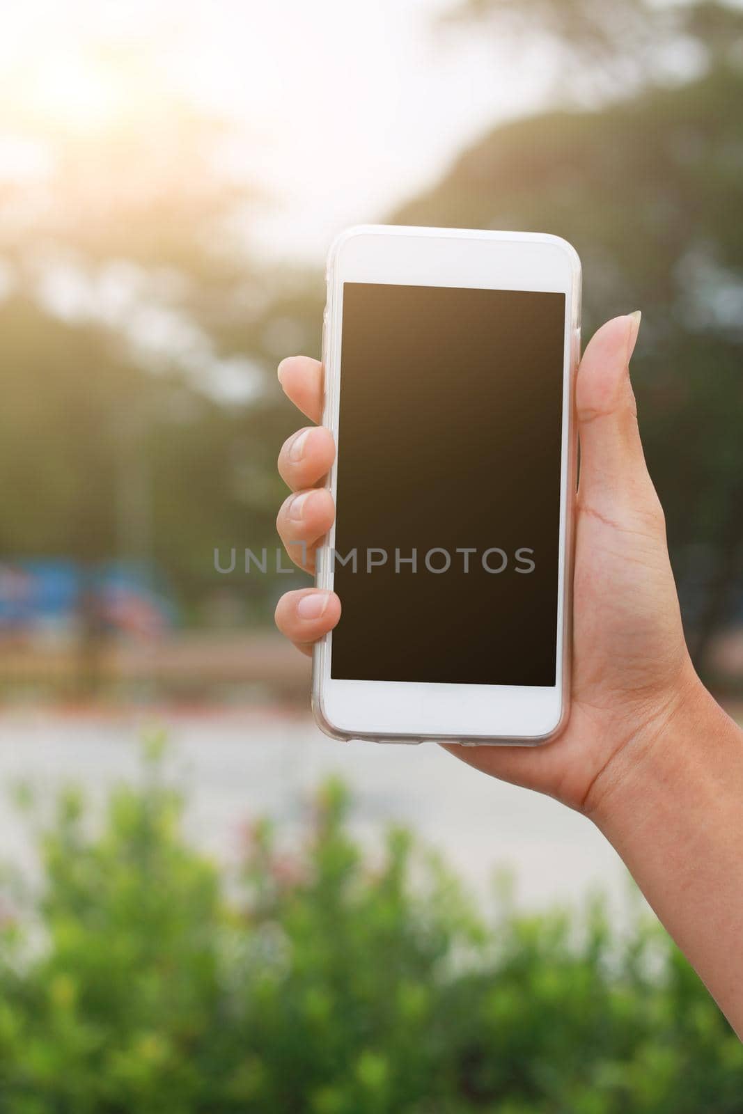 Hand holding phone isolated on black clipping inside