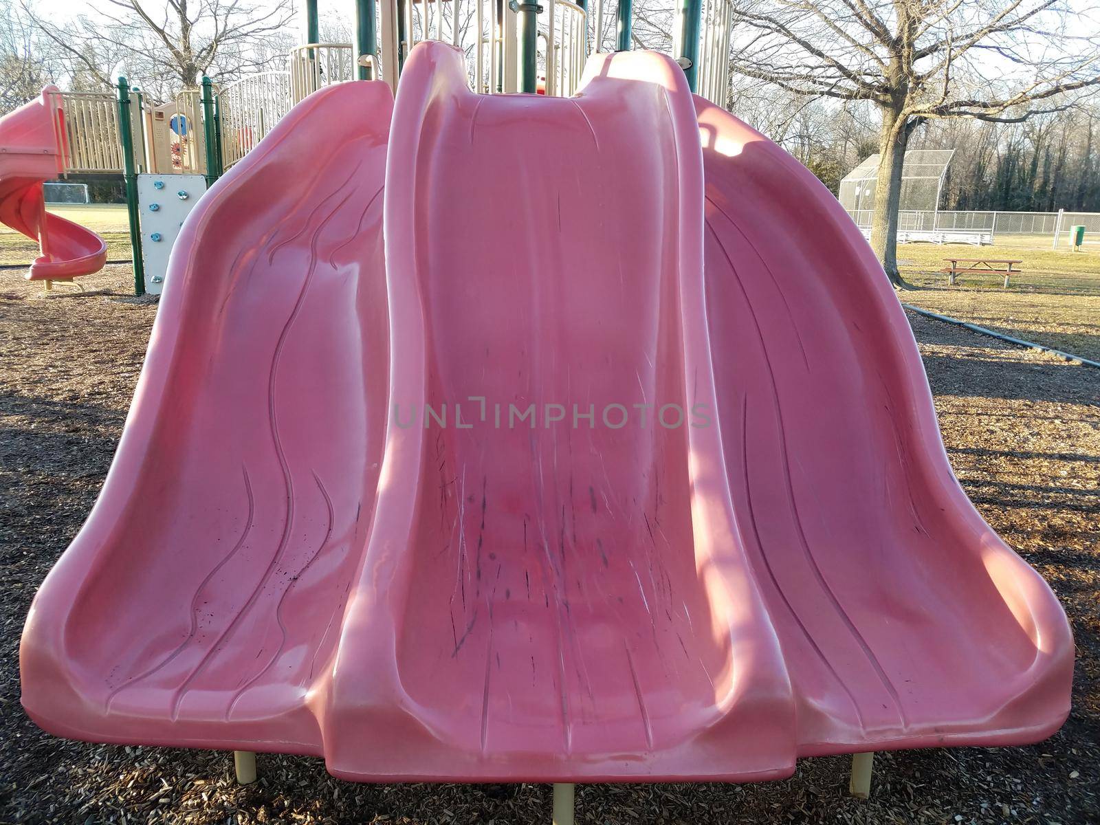 steep red or pink plastic slide at park playground