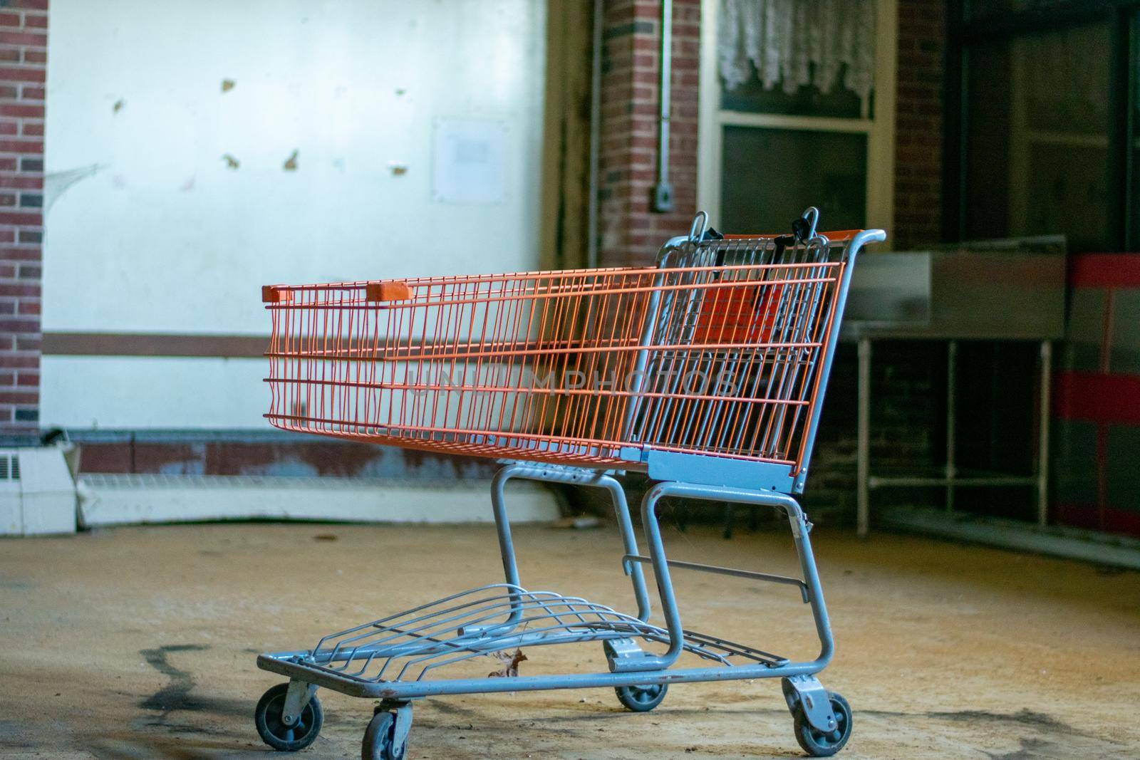 A Shopping Cart Inside an Empty Room in an Abandoned Building by bju12290