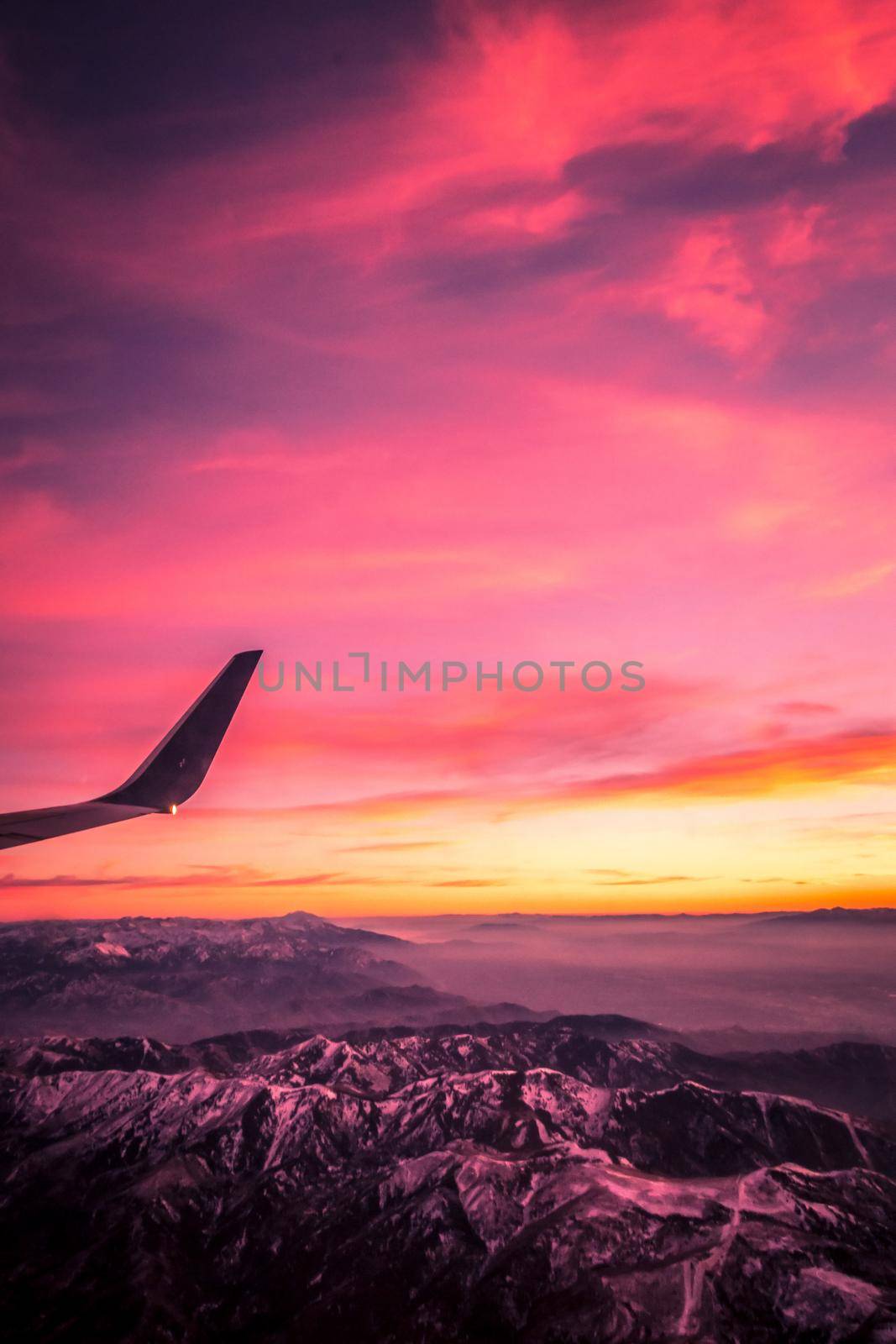 flying over rockies in airplane from salt lake city at sunset by digidreamgrafix