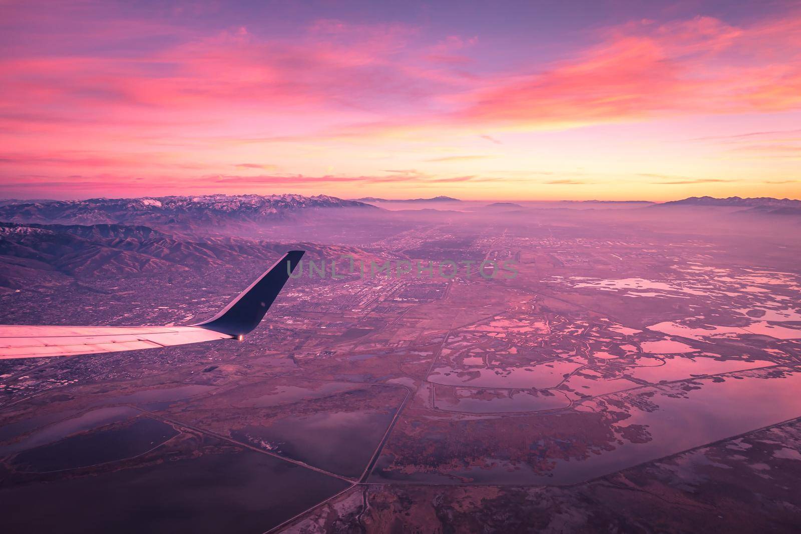 flying over rockies in airplane from salt lake city at sunset