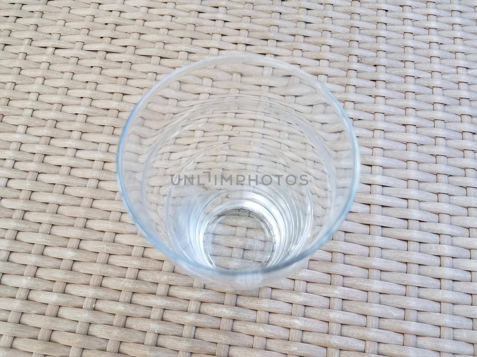 tall clear drinking glass on brown wicker table