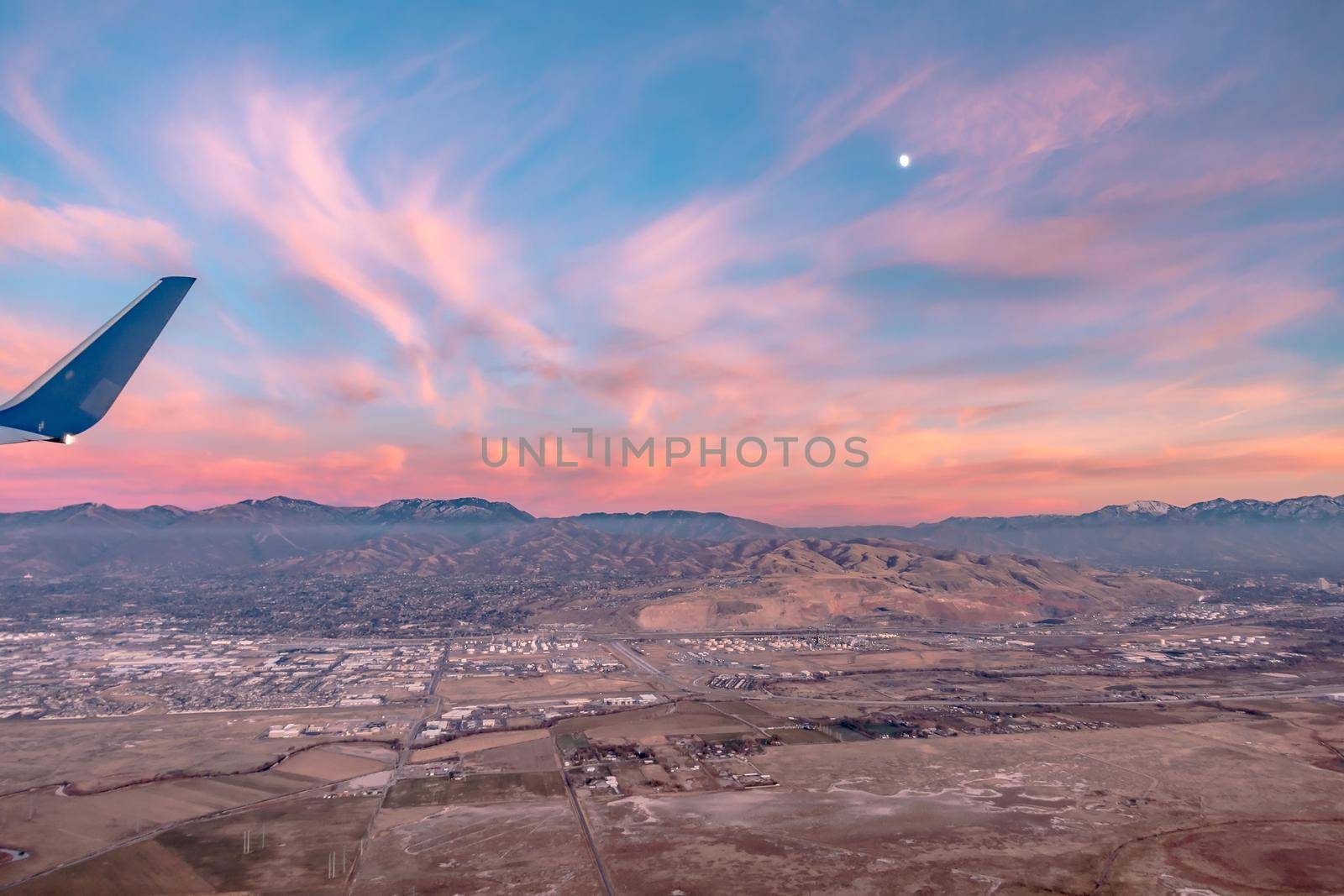 flying over rockies in airplane from salt lake city at sunset by digidreamgrafix