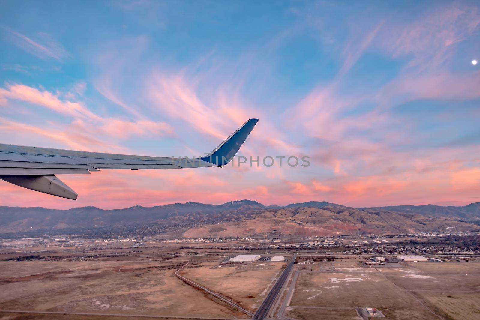 flying over rockies in airplane from salt lake city at sunset by digidreamgrafix