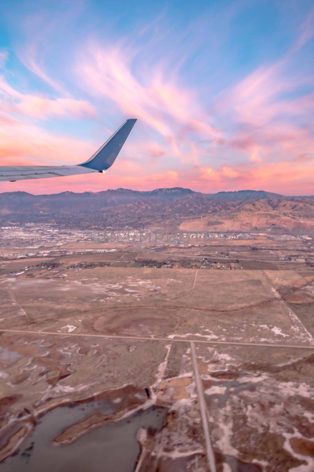 flying over rockies in airplane from salt lake city at sunset by digidreamgrafix