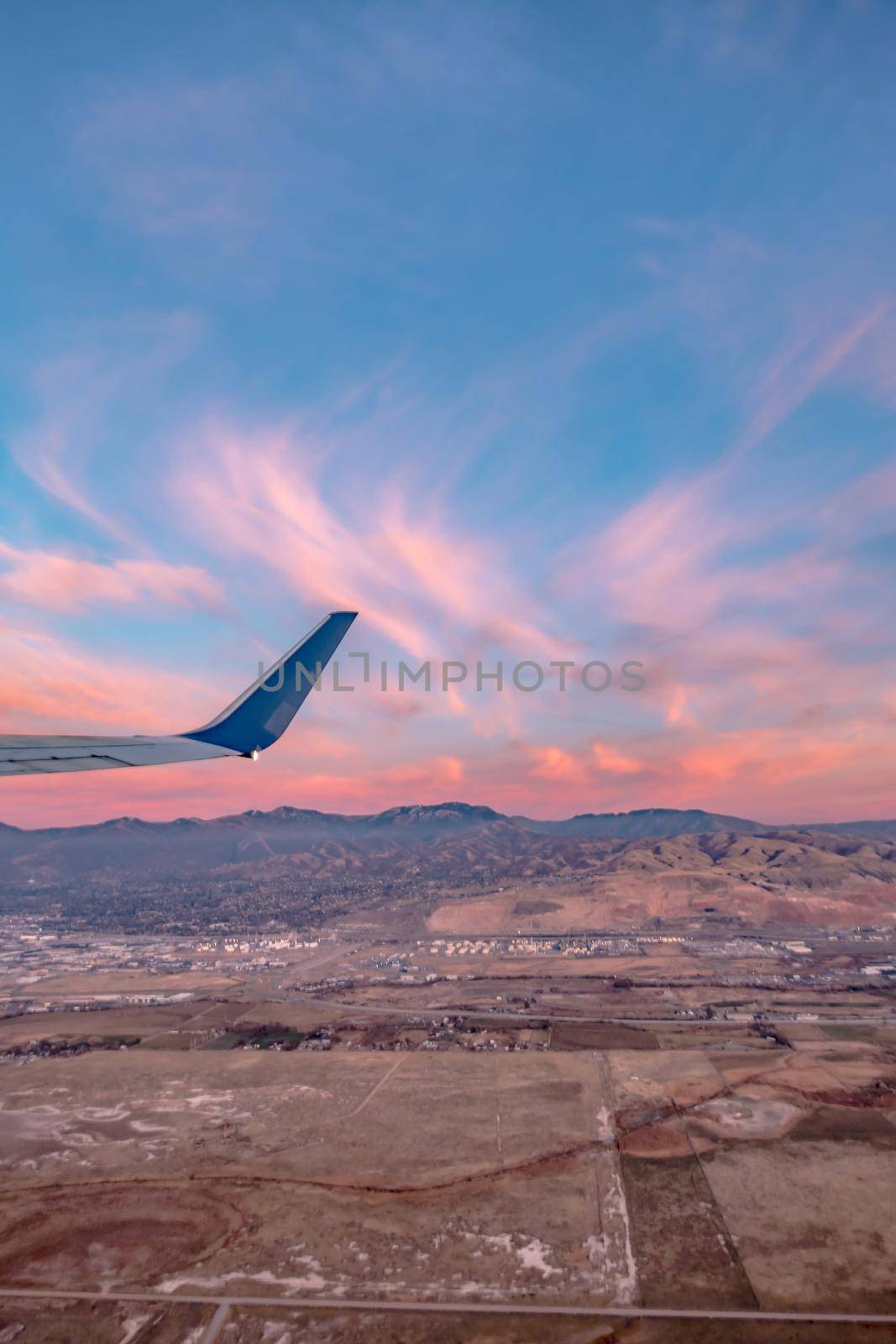 flying over rockies in airplane from salt lake city at sunset