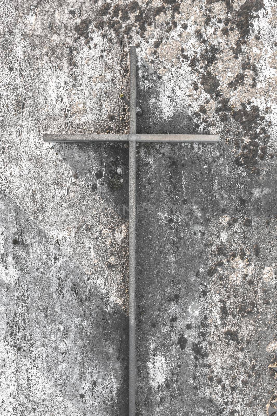 Iron christian cross on an old concrete wall