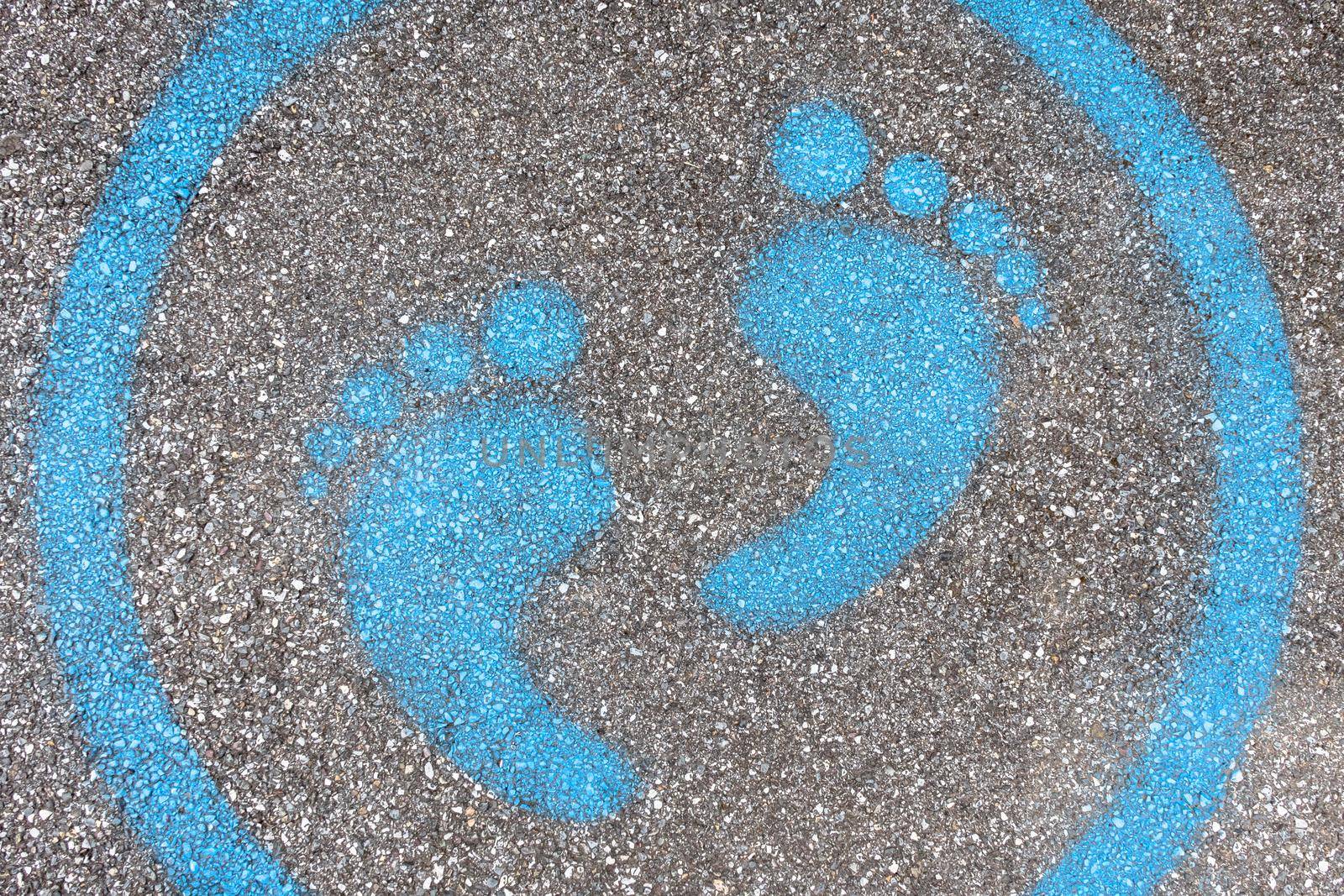 Sign painted on the pavement reminding users to maintain a physical distance of 3 feet / 1 meter during the COVID-19 pandemic.