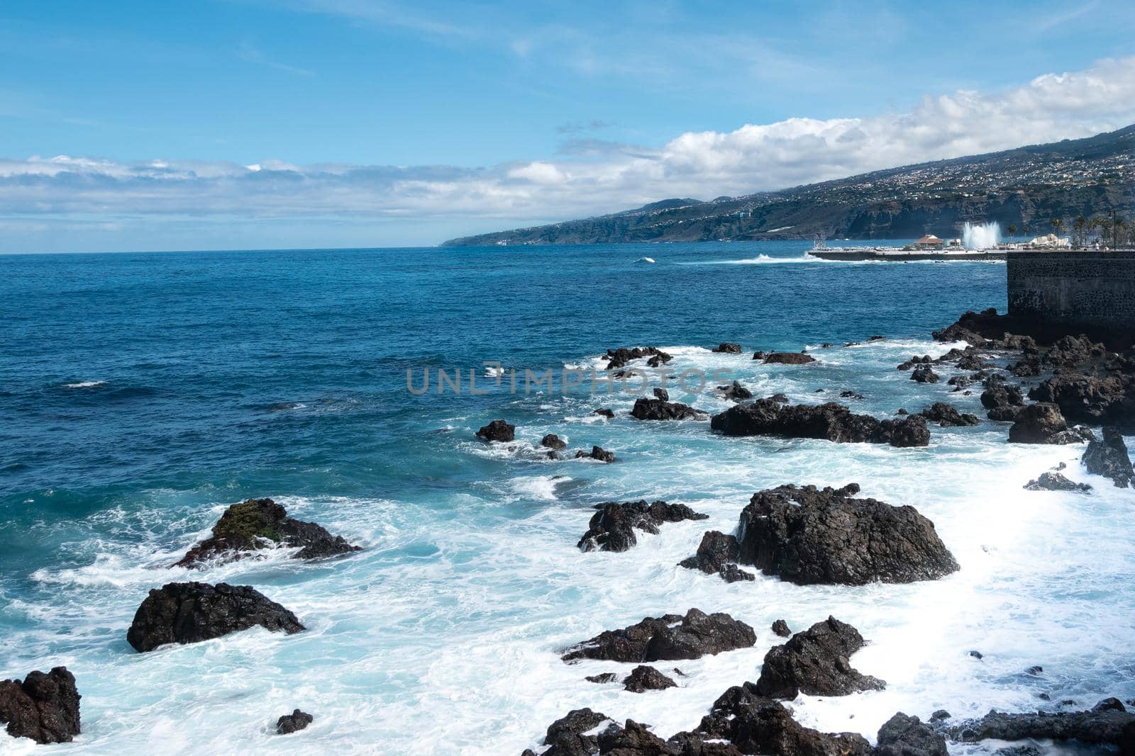 A Beautiful shot of foam waves hitting a rocky seashore