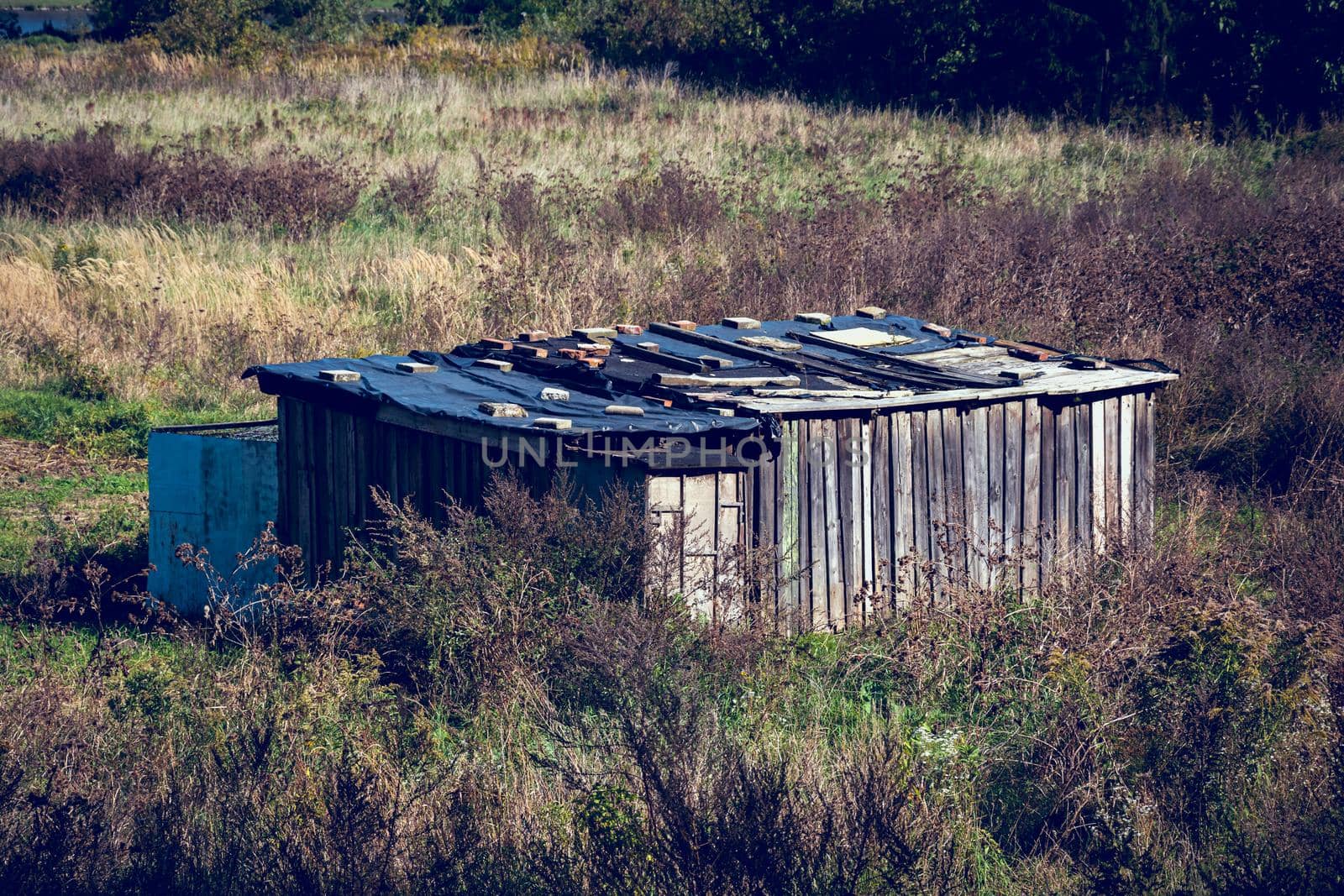 Old weathered wooden hut in the middle of the field