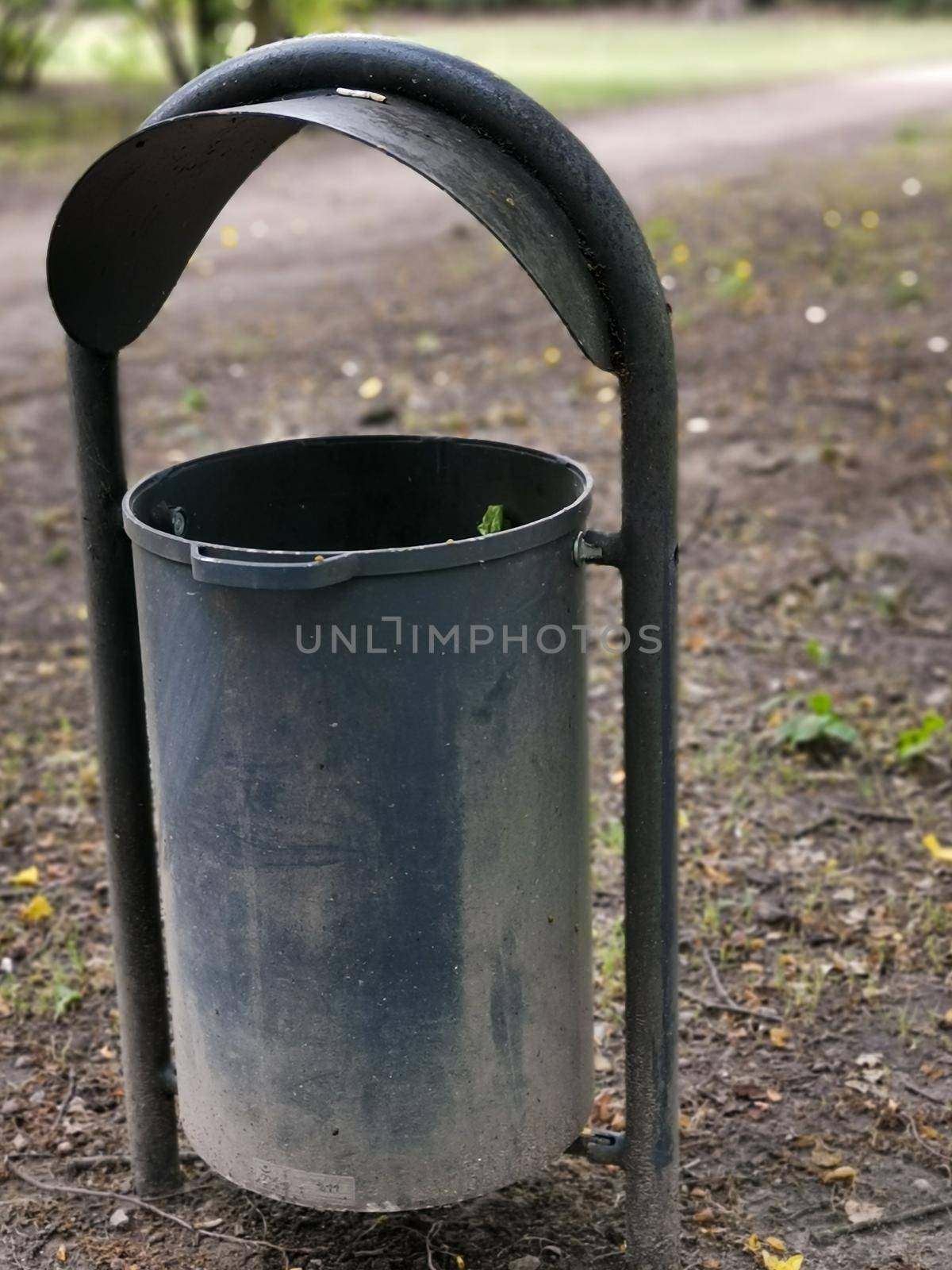 Vertical closeup shot of an empty public trash can in a park