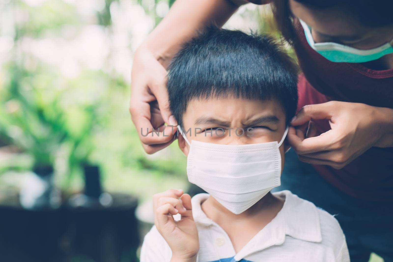 Mother take care son with face mask for protection disease flu or covid-19 outdoors, mom wearing on medical mask with child safety for protect outbreak of pandemic in public, medical concept.