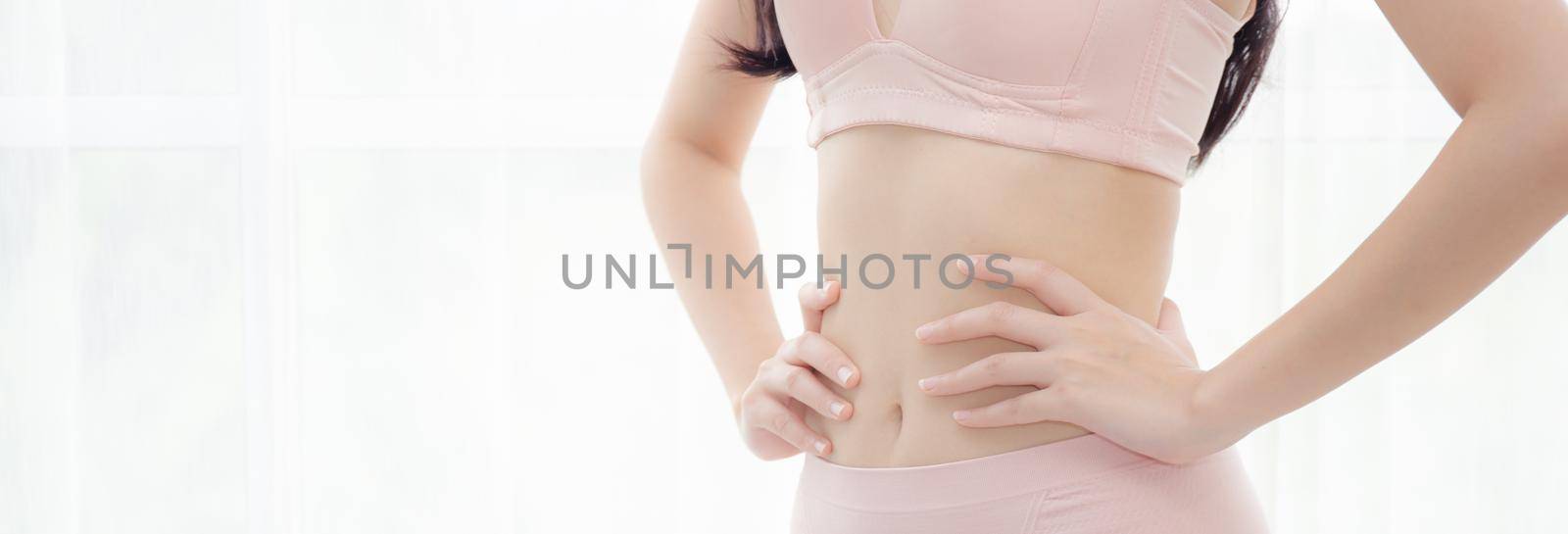 Closeup asian woman wear underwear beautiful body belly slim shape sexy with diet at room, girl wear bra hand touch abdomen thin with weight loss, health and wellness concept, banner website.