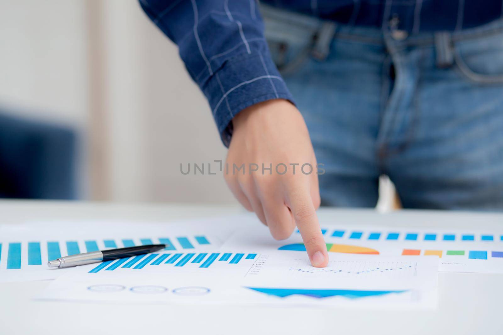 Hand of young business man pointing document data graph and chart paper, marketing and investment, report of statistics profit for financial, economic and growth of finance, management and planning.