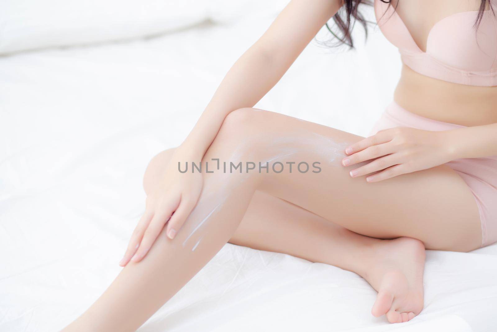 Beautiful young asian woman touch skin leg smooth with cream and lotion for hydration and smooth, girl applying body care and cosmetic for silky and soft, beauty perfect with wellness, health and care.