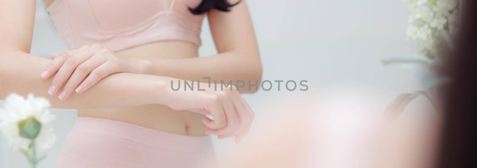 Beautiful sexy young asian woman looking mirror applying cream on arms and message, beauty girl applying body lotion skin care for soft, treatment and cosmetic with moisturizer, banner website.