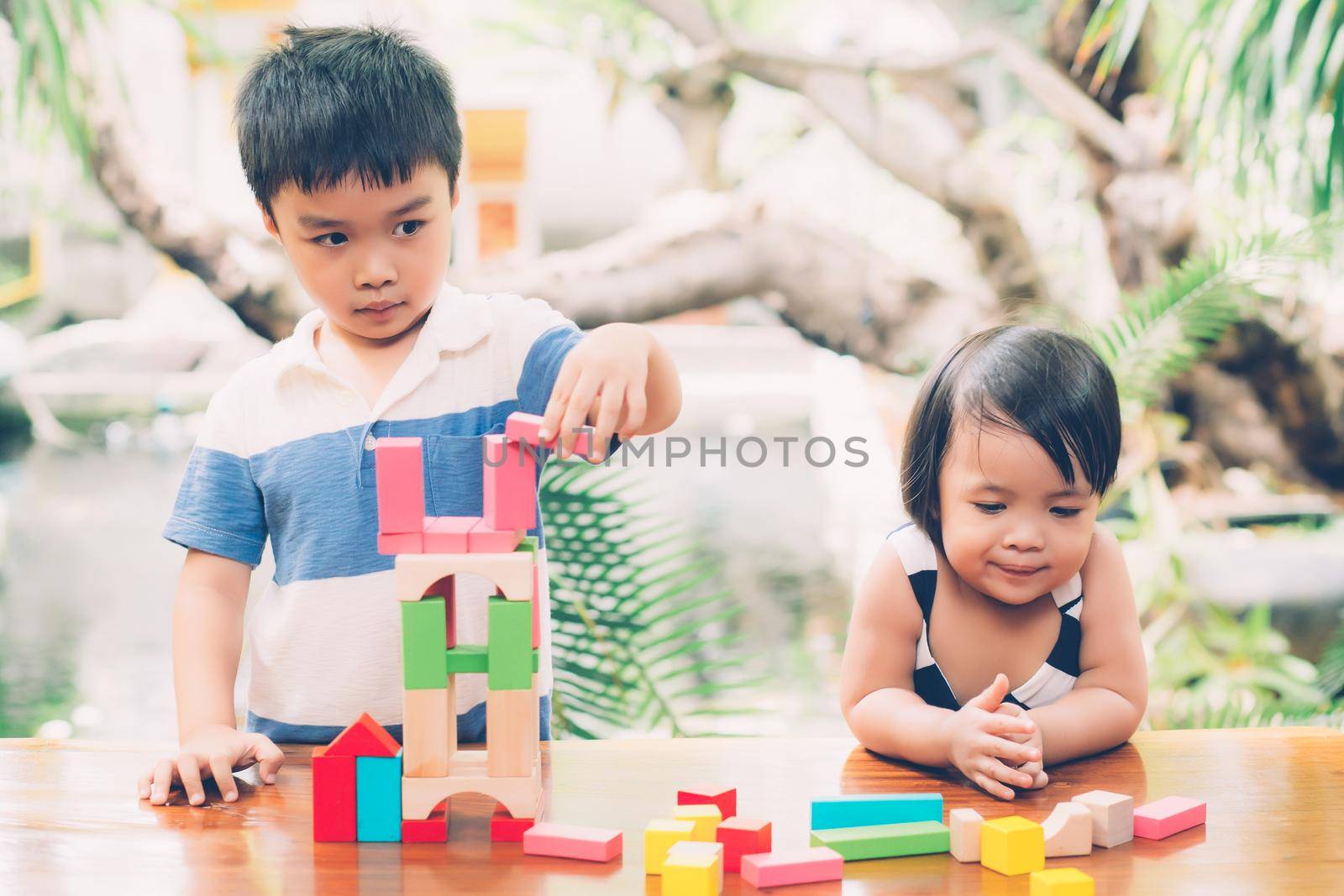 Asian boy and gril playing wooden block toy on table for creative and development with enjoy, happy child learn skill for activity puzzle and creativity for game on desk at home, education concept.