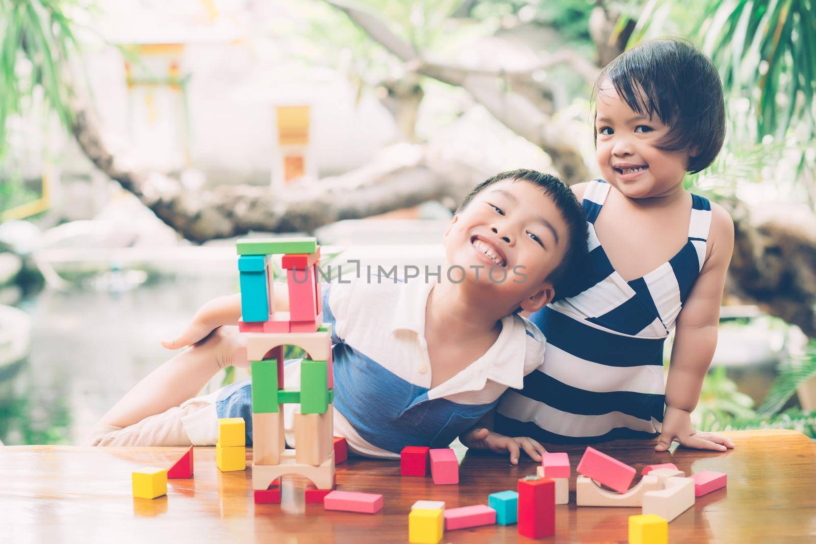 Asian boy and gril playing wooden block toy on table for creative and development with enjoy, happy child learn skill for activity puzzle and creativity for game on desk at home, education concept. by nnudoo