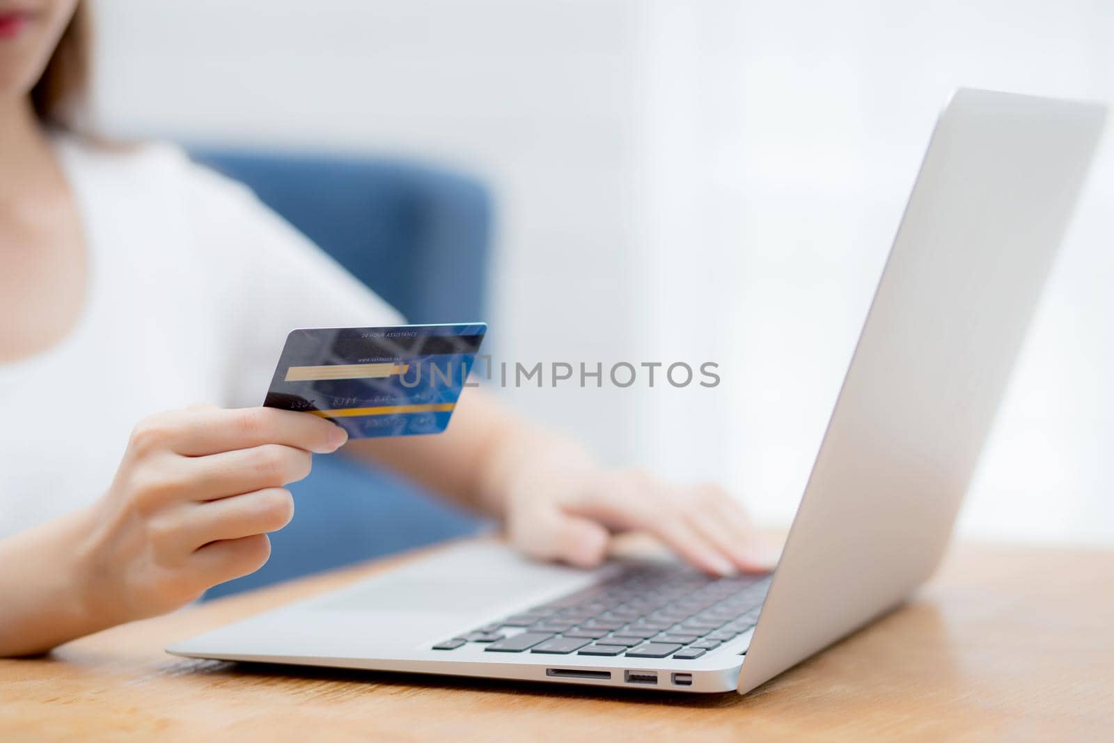 Hand of young woman holding credit card buying shopping online with laptop computer, girl purchase and payment on internet, commerce and e-business, transaction for finance, business concept.