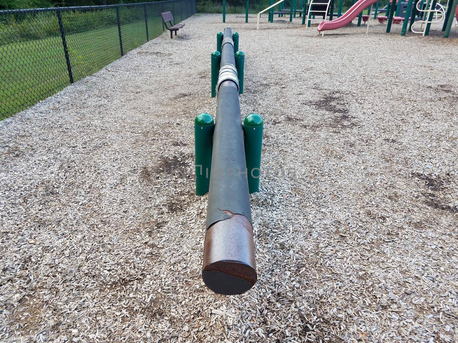 long balance beam at playground with brown wood chips by stockphotofan1
