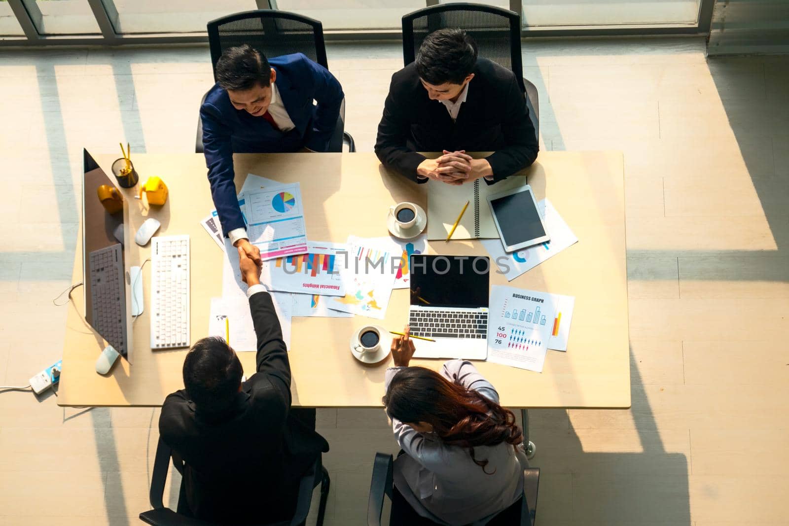 Top view on a group of businessman and businesswoman having a meeting and making a business commitment. by chuanchai