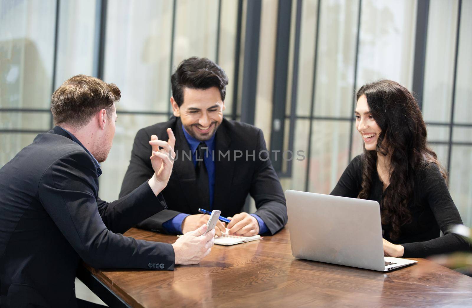 Young business team discussing and studying statistics in a meeting room by chuanchai