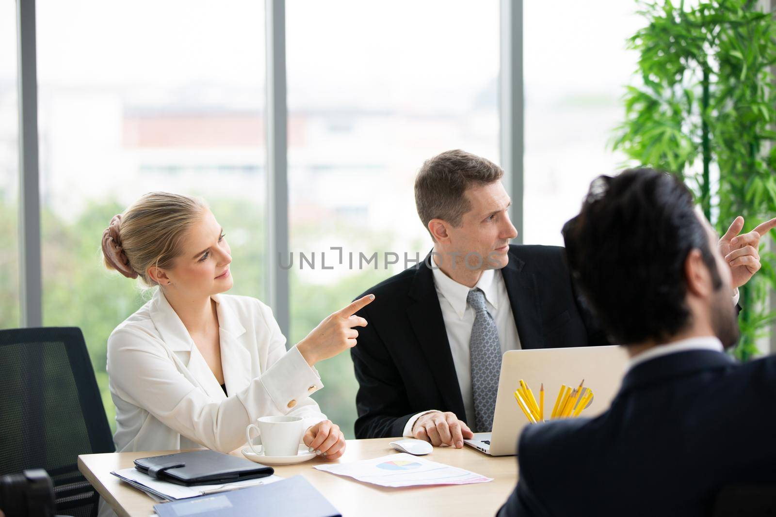 young business team working together at office. Manager pointing at a chart and explaining the analysis about business strategies. Top view shot of business hand shake