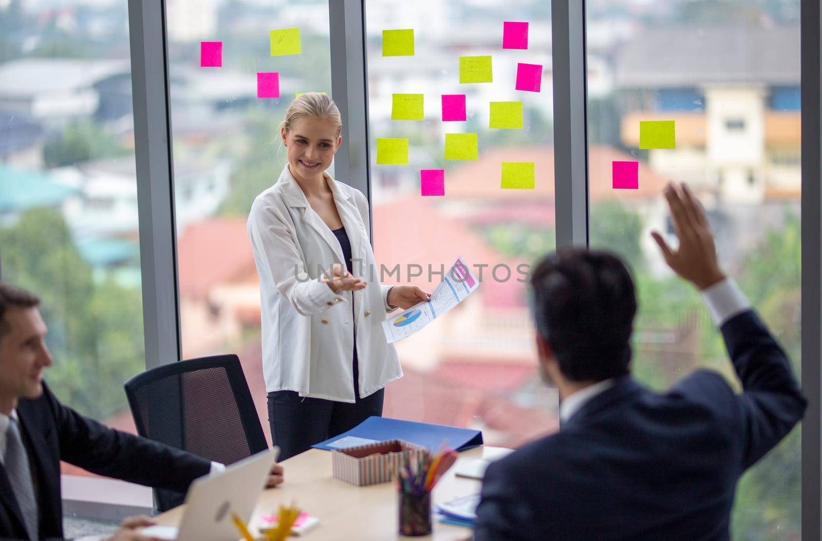 young business team working together at office. Manager pointing at a chart and explaining the analysis about business strategies. Top view shot of business hand shake