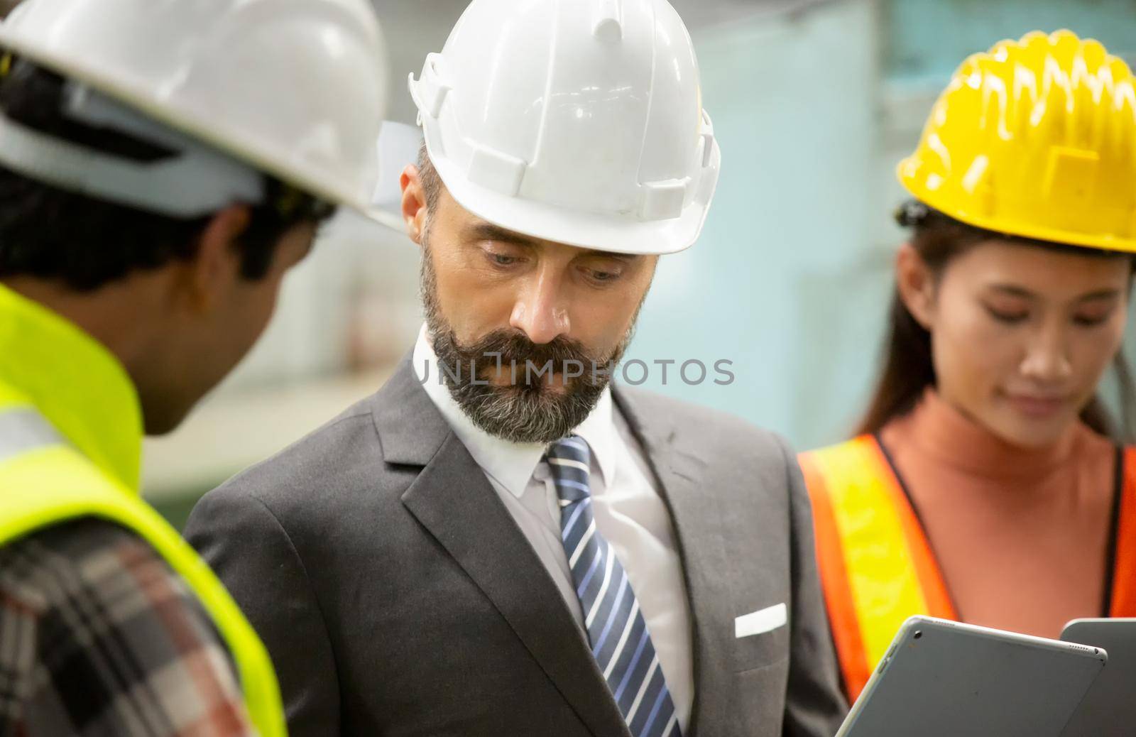 Male Industrial Engineers Talk with Factory Worker . They Work at the Heavy Industry Manufacturing Facility.