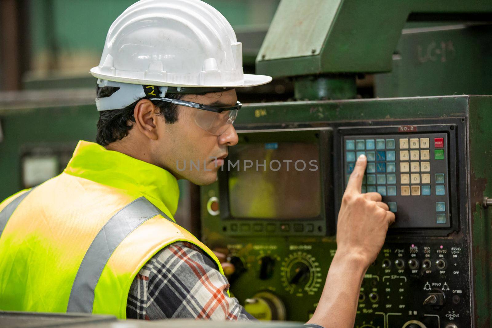 Engineers operating a cnc machine in factory