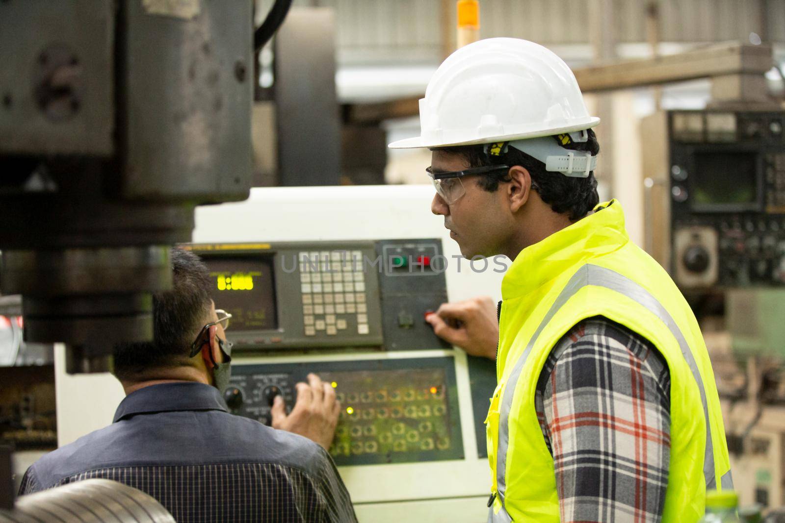 Engineers operating a cnc machine in factory