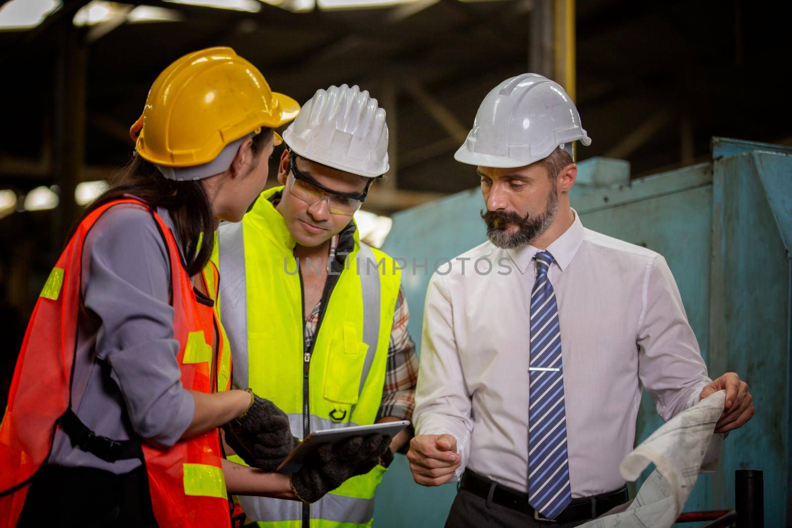 Male Industrial Engineers Talk with Factory Worker . They Work at the Heavy Industry Manufacturing Facility.