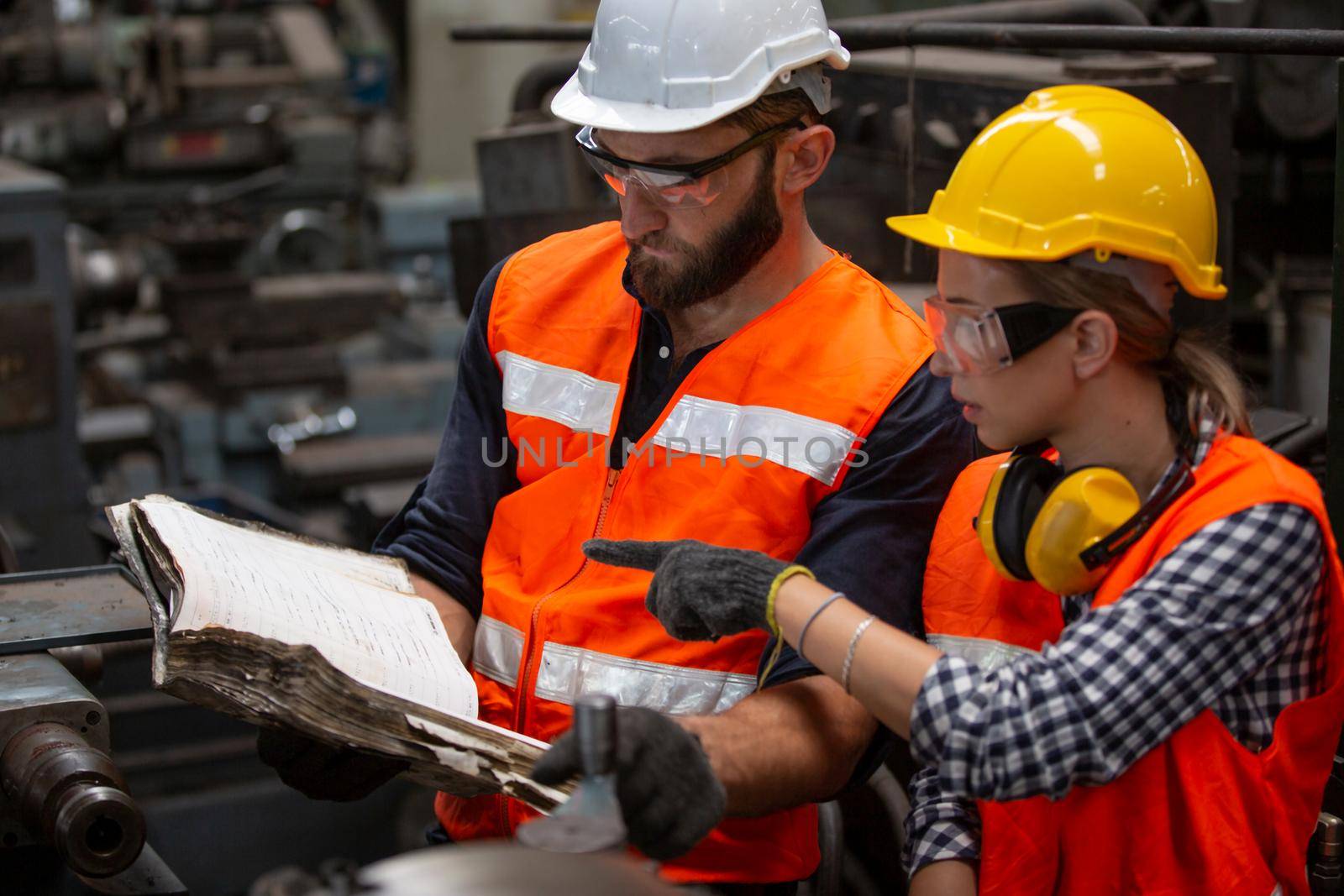 Engineers operating a cnc machine in factory