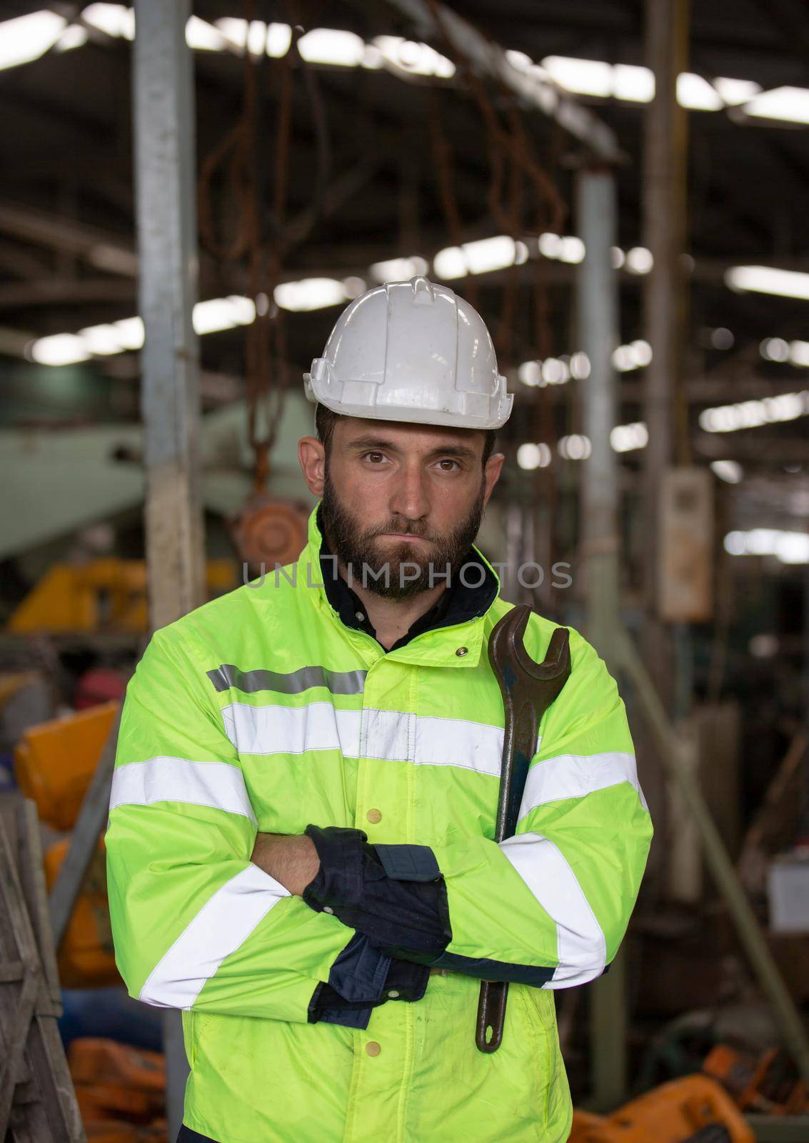 Engineer standing with confident against machine environment in factory