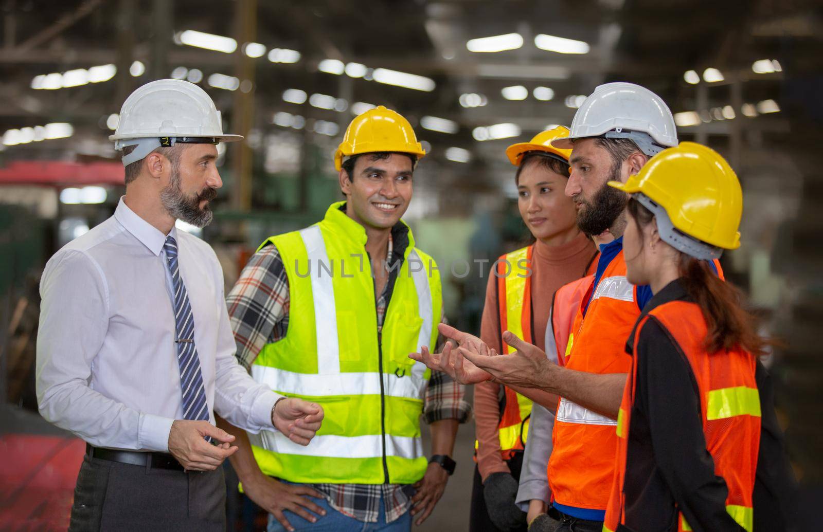 Male Industrial Engineers Talk with Factory Worker . They Work at the Heavy Industry Manufacturing Facility.