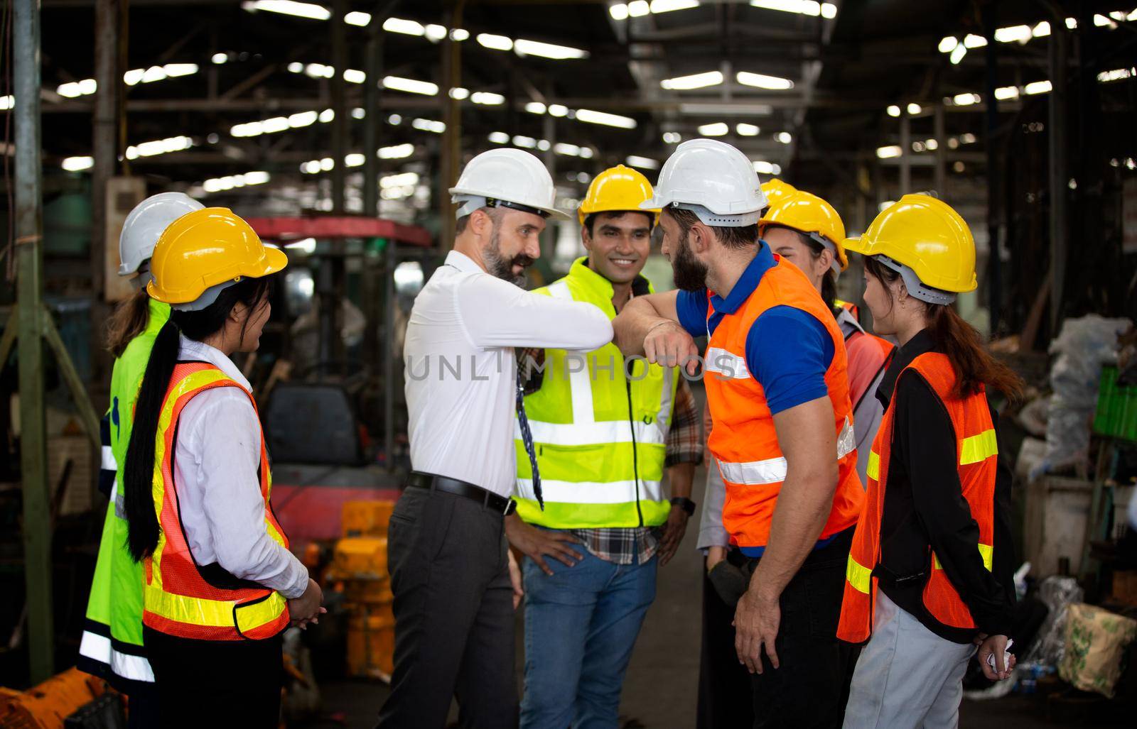 Male Industrial Engineers Talk with Factory Worker . They Work at the Heavy Industry Manufacturing Facility.