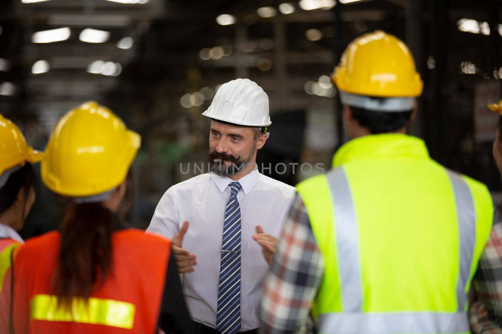 Male Industrial Engineers Talk with Factory Worker . They Work at the Heavy Industry Manufacturing Facility.