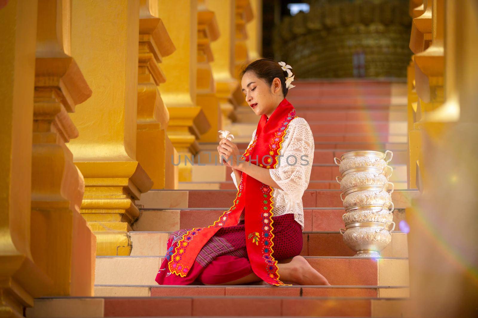 Women Burmese Buddhist faithful are walking barefoot around the Shwedagon Pagoda wearing a traditional and colorful Longyi (traditional Burmese clothes). Yangon, Myanmar.